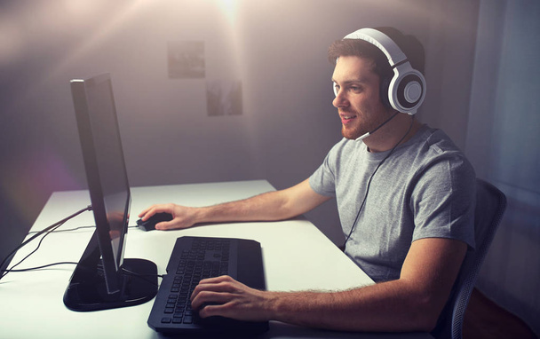 man in headset playing computer video game at home - Foto, imagen