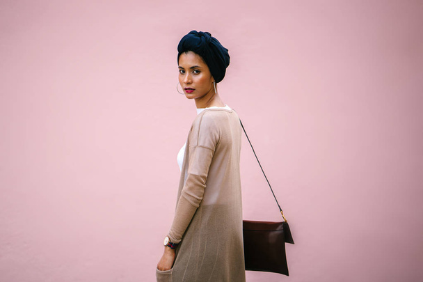 Портрет молодой, красивой арабской мусульманки в синем тюрбане. Она элегантно одета в консервативную, но современную и минималистскую одежду, которая является модной
. - Фото, изображение