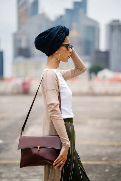 Portrait of a young Muslim woman (Islam) wearing a turban (headscarf, hijab). She is elegant, attractive and professionally dressed. - Fotó, kép