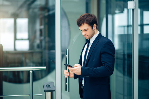 businessman with smartphone over office building - Foto, Bild