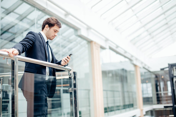 businessman with smartphone over office building - Photo, Image