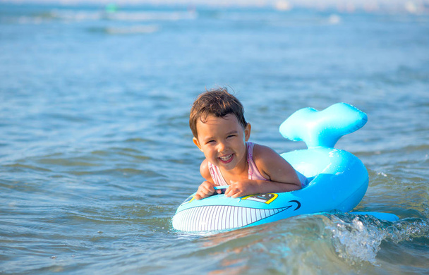 Petite fille nageant sur gonflable à la mer
 - Photo, image