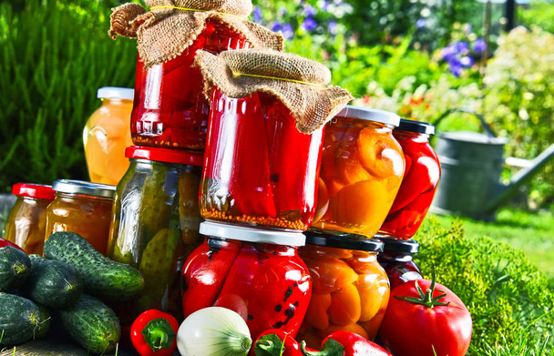 Frascos de verduras en escabeche y frutas en el jardín
 - Foto, imagen