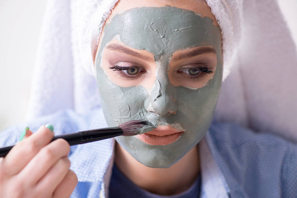 Woman applying clay mask with brush at home - Photo, Image