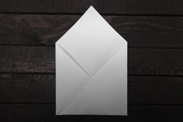 Белый открытый конверт сверху на дереве. Градиентный фильтр
. - Фото, изображение