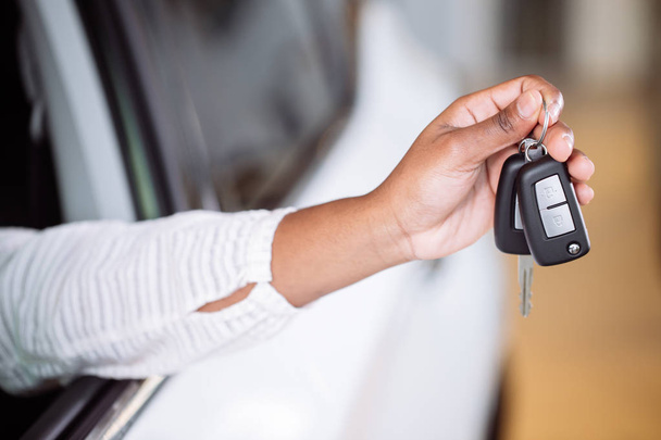 african woman with her new car showing key - Foto, Imagem