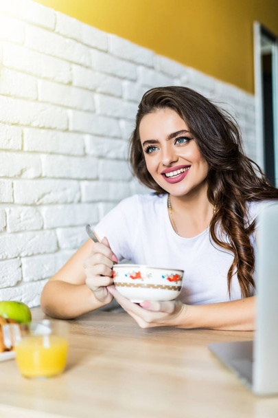 Beautiful young woman breakfast in the kitchen - Photo, Image