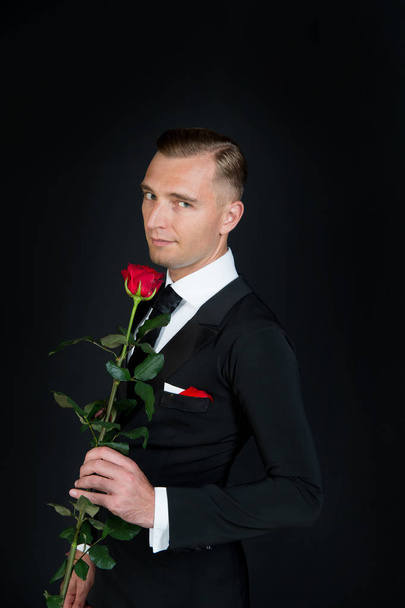 Man with red rose on dark background - Fotoğraf, Görsel