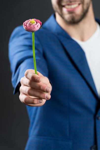 Flower in male hand in blue suit, valentine present - Photo, Image