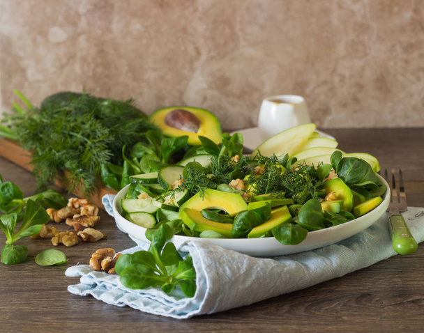 Green avocado cucumber salad with corn salad, apple, walnuts and dill. Detox food lunch. Diet concept. - Foto, Imagen
