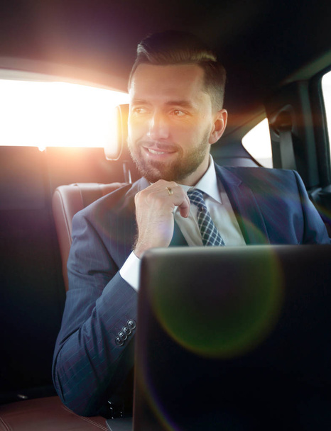successful man sitting in the back seat of a car - Фото, изображение