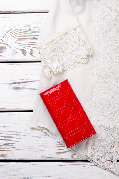 Witte lace blouse en rode portemonnee, close-up. - Foto, afbeelding