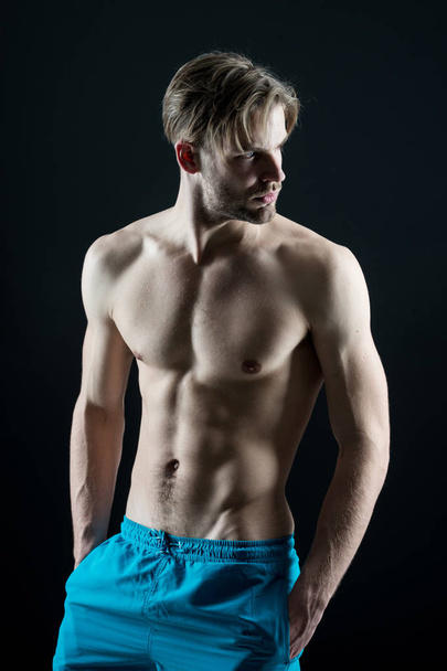 Man athlete show muscular torso in blue shorts - Foto, afbeelding