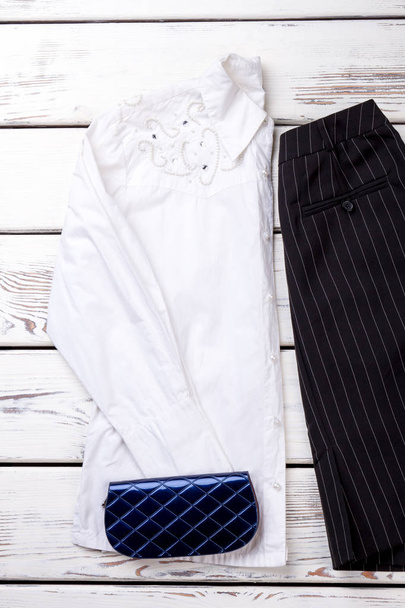 Blusa blanca decorada para mujer y billetera azul
. - Foto, Imagen