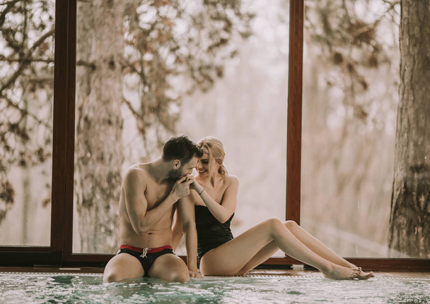 Couple aimant se détendre dans le centre spa au bord de la piscine
 - Photo, image