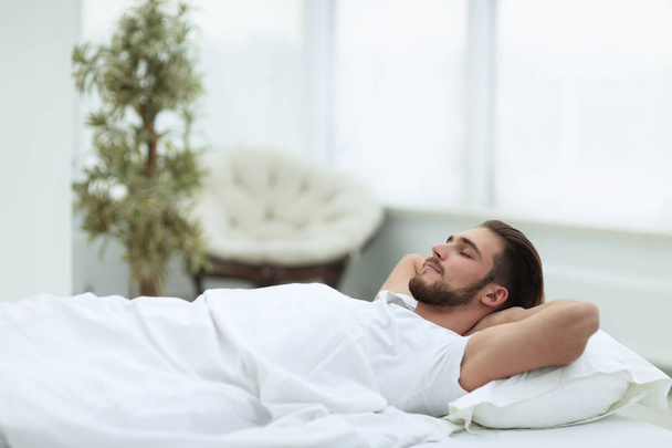 tired man resting on a comfortable bed - Fotografie, Obrázek