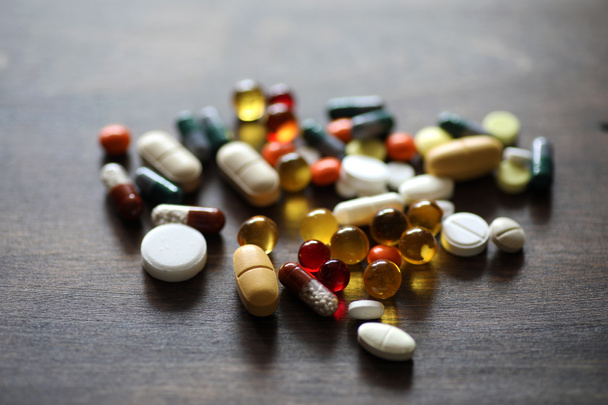 Medicijnen en tabletten op een houten structuur tafel - Foto, afbeelding