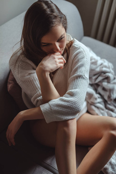 Sexy girl with long legs sitting on a sofa - Foto, afbeelding