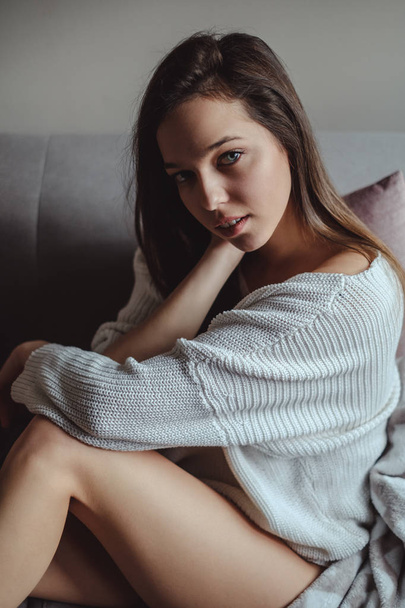 Portrait of a sexy girl sitting on a sofa - Photo, Image
