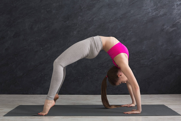 Γυναίκα εκπαίδευση yoga σε πίνακα κορυφή πόζα. - Φωτογραφία, εικόνα
