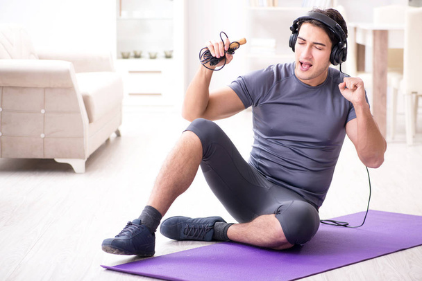 Man doing sports at home and listening to music - Foto, Imagen
