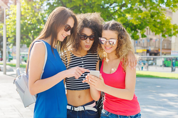 Happy female friends with smartphone outdoors - 写真・画像