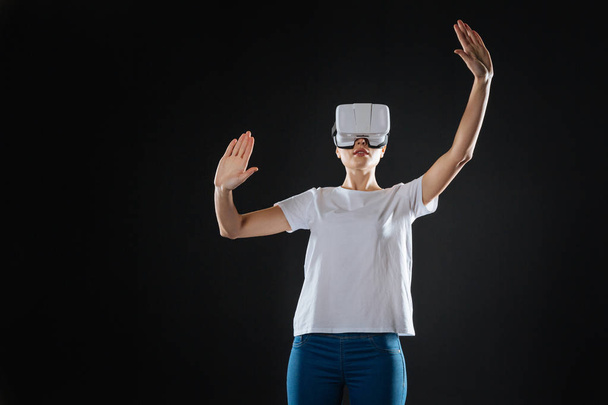 Occupied interested woman standing and tasting VR glasses. - Foto, imagen