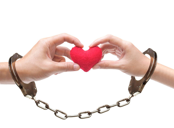 Een paar ' handen met als een rood hart samen met hand manchetten / liefde en Romaans op Valentijnsdag concept       - Foto, afbeelding