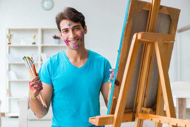 Młody zabawny artysta pracujący nad nowym malarstwem w swoim studio - Zdjęcie, obraz