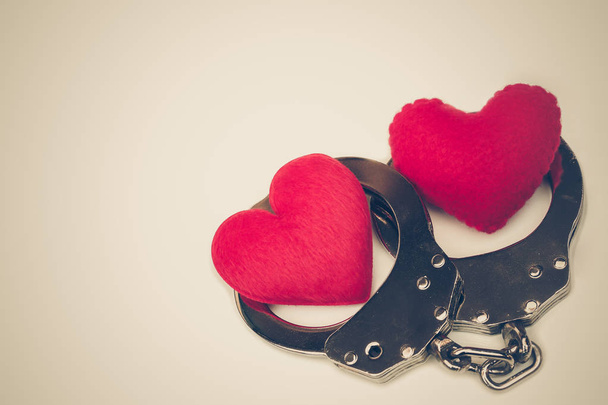 Handcuffs with a red love heart with copy space to add text - Фото, изображение