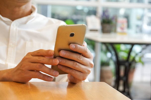 Mężczyzna ręcznie przy użyciu smartfona w kawiarni - Zdjęcie, obraz