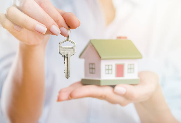 Woman holding little house model and key - Φωτογραφία, εικόνα