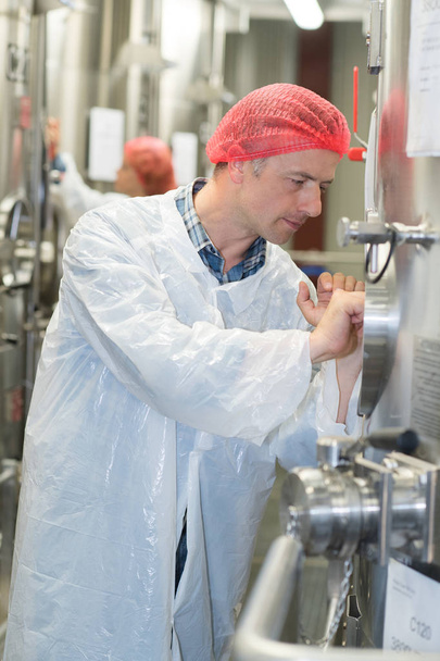 pracownik blokowania kreskowania metalowe kadzi do fermentacji wina fabryki - Zdjęcie, obraz