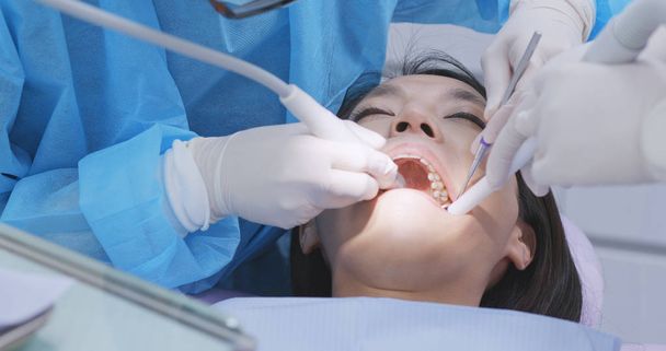 Patiënt ondergaan tandheelkundige behandeling in tandheelkundige kliniek  - Foto, afbeelding