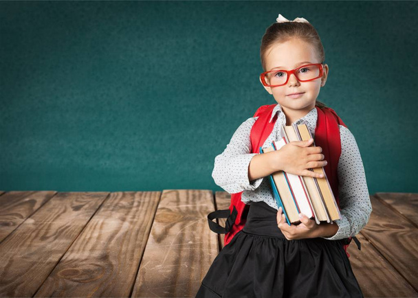 photo of young cute girl in red glasses study at school on green chalkboard background - Fotoğraf, Görsel