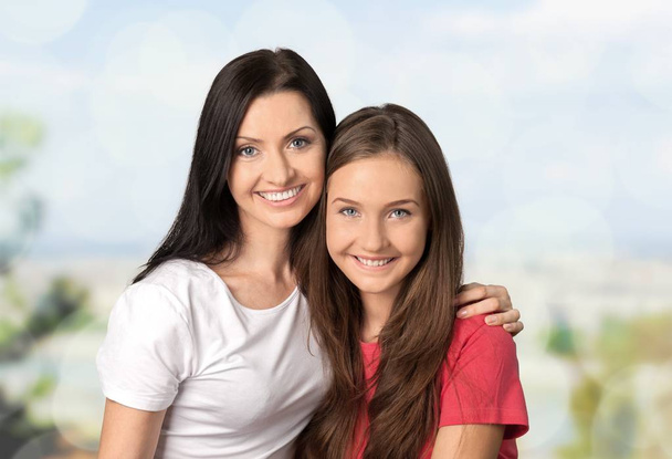 Mother with teenage daughter isolated on background - Foto, Imagen