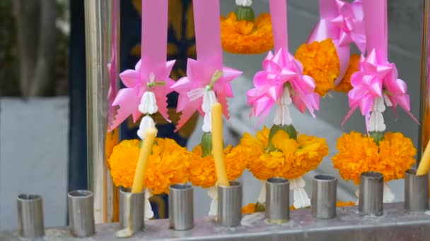 Viasz gyertyák és virágok közelében hagyományos buddhista oltár Thaiföldön - Felvétel, videó