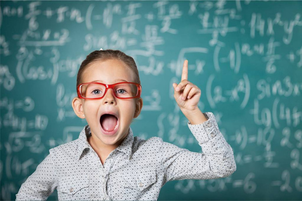 photo of young cute girl in red glasses study at school on green chalkboard background - Fotografie, Obrázek