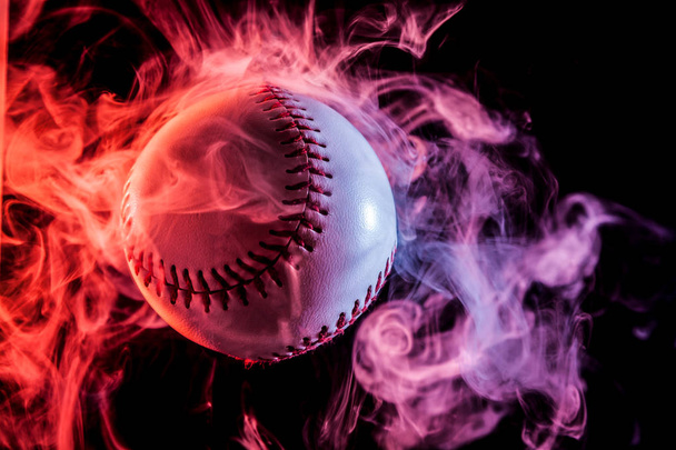 マルチカラー赤黒の孤立した背景にワイプから煙で白い野球ボール - 写真・画像
