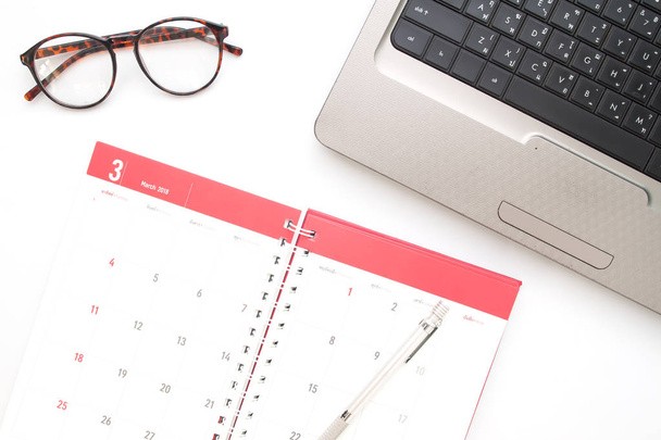 Práce s notebookem a organizování měsíční aktivity a schůzky v kalendáři, pohled shora - Fotografie, Obrázek