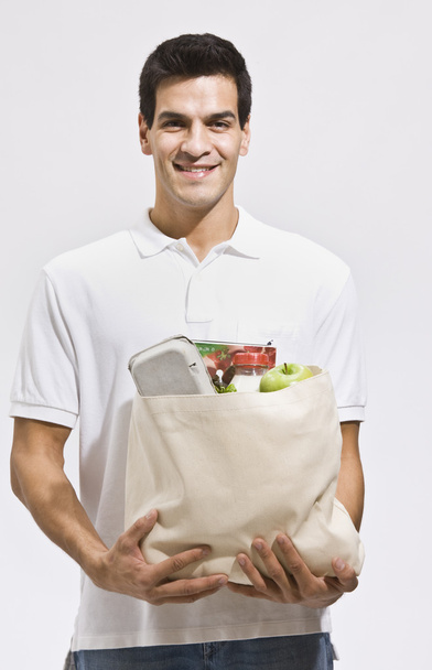 Hombre atractivo sosteniendo comestibles
 - Foto, Imagen