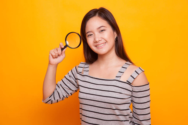 Young Asian woman with a magnifying glass. - Foto, Imagen