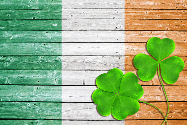 Зеленый клевер листья или шампуни на деревянном фоне в цвет ирландского флага.
. - Фото, изображение