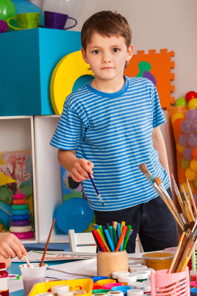 Маленькие ученики мальчика живописи в классе художественной школы
. - Фото, изображение