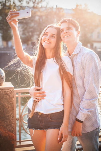 young man and woman taking selfie on smartphone on street - Valokuva, kuva