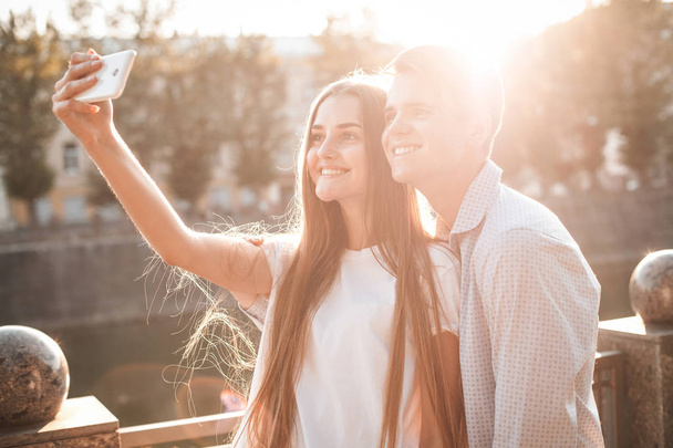 young man and woman taking selfie on smartphone on street - Foto, immagini