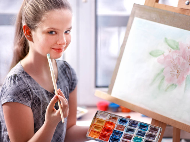Künstler malen auf Staffelei im Atelier. Mädchen malt mit Pinsel. - Foto, Bild