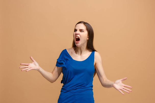 Молода емоційна розлючена жінка кричить на пастельному студійному фоні
 - Фото, зображення