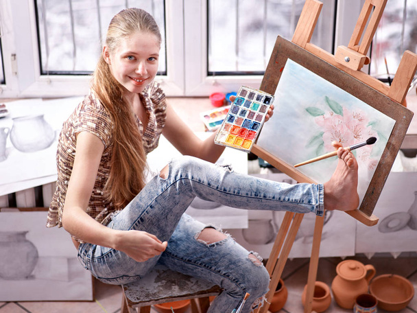 Pintura de artista sobre caballete en estudio. Pinturas de niña con pincel
. - Foto, Imagen