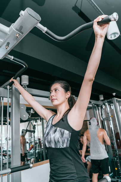 Woman doing exercises on a pull-up machine - Photo, image